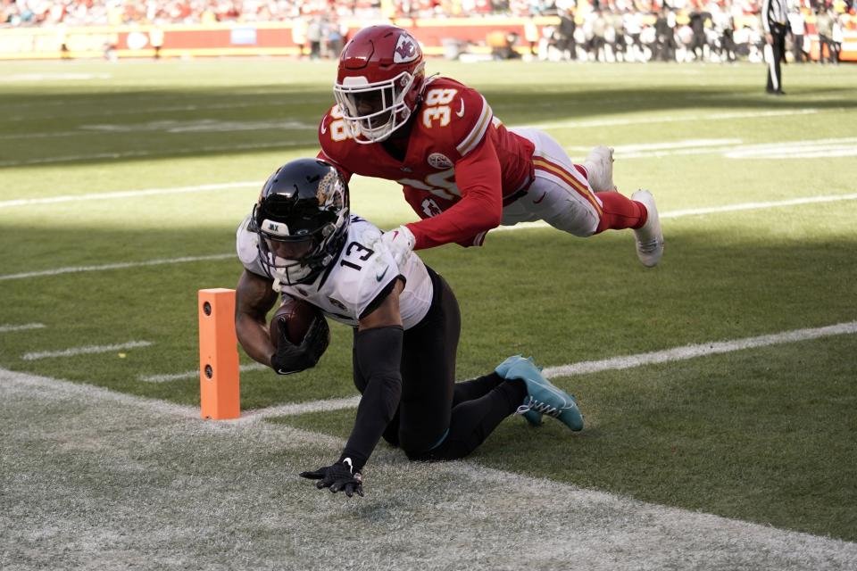 Jacksonville Jaguars wide receiver Christian Kirk (13) catches a touchdown pass as Kansas City Chiefs cornerback L'Jarius Sneed (38) defends during the first half of an NFL football game Sunday, Nov. 13, 2022, in Kansas City, Mo. (AP Photo/Ed Zurga)