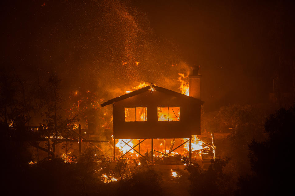 <p>The Lilac Fire consumes a house on December 8 near Bonsall, California. </p>