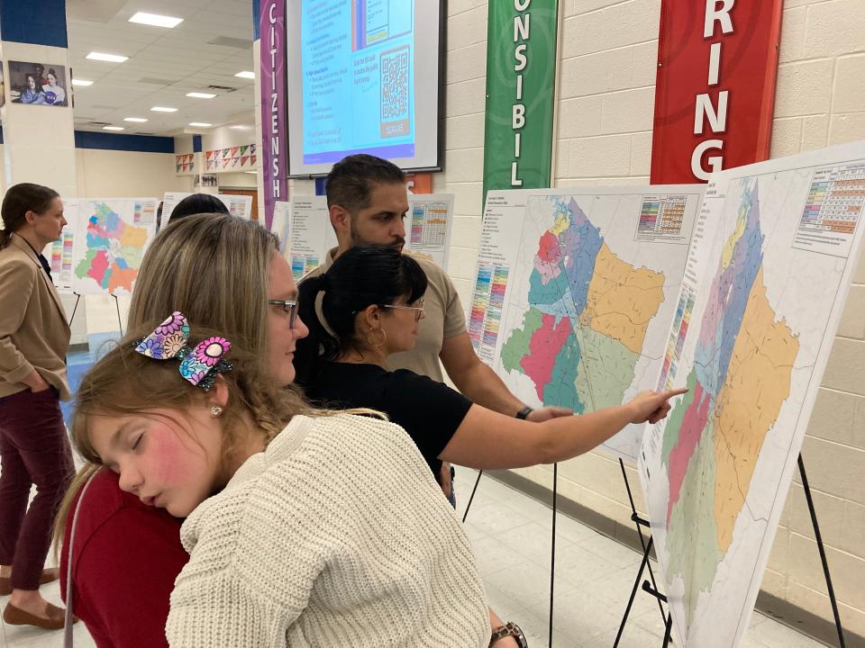 Brown's Chapel Elementary School mother Mackenzie Bray holds her 5-year-old daughter, Maci, Monday, Sept. 18, 2023, while examining proposed rezoning maps for Rutherford County Schools during a parent-input night at the La Vergne High School campus.