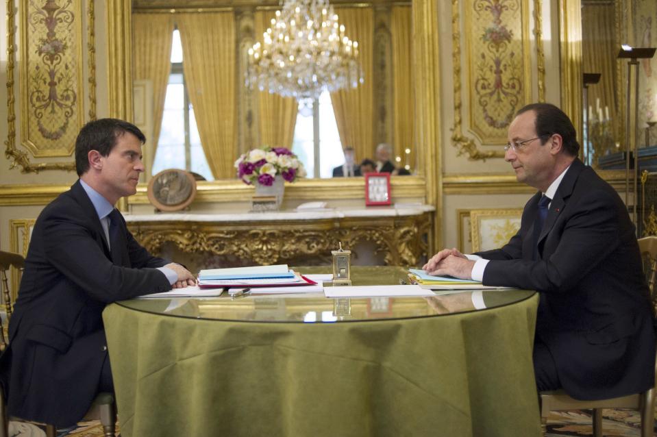 France's newly appointed Prime minister Manuel Valls, left, speaks with French President Francois Hollande before the first cabinet meeting of his government at the Elysee Palace in Paris, Friday, April 4, 2014. Hollande shook up the government this week after his Socialist Party suffered an electoral defeat in nationwide municipal elections. Among two new faces in the Cabinet is Segolene Royal, a longtime politician and mother of Hollande's children, as environment and energy minister. (AP Photo/Fred Dufour, Pool)