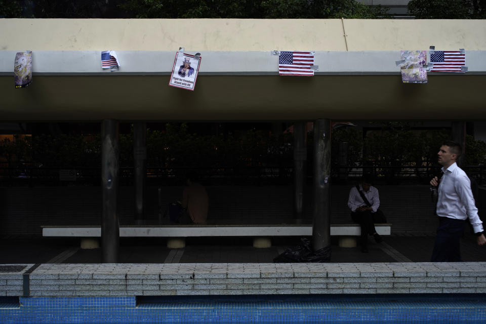 A man walks past posters left by protesters in Hong Kong, Tuesday, Oct. 15, 2019. A homemade, remote-controlled bomb intended to "kill or to harm" riot control officers was detonated as they deployed against renewed violence in Hong Kong over the weekend, police said Monday, in a further escalation of destructive street battles gripping the business hub. (AP Photo/Vincent Yu)