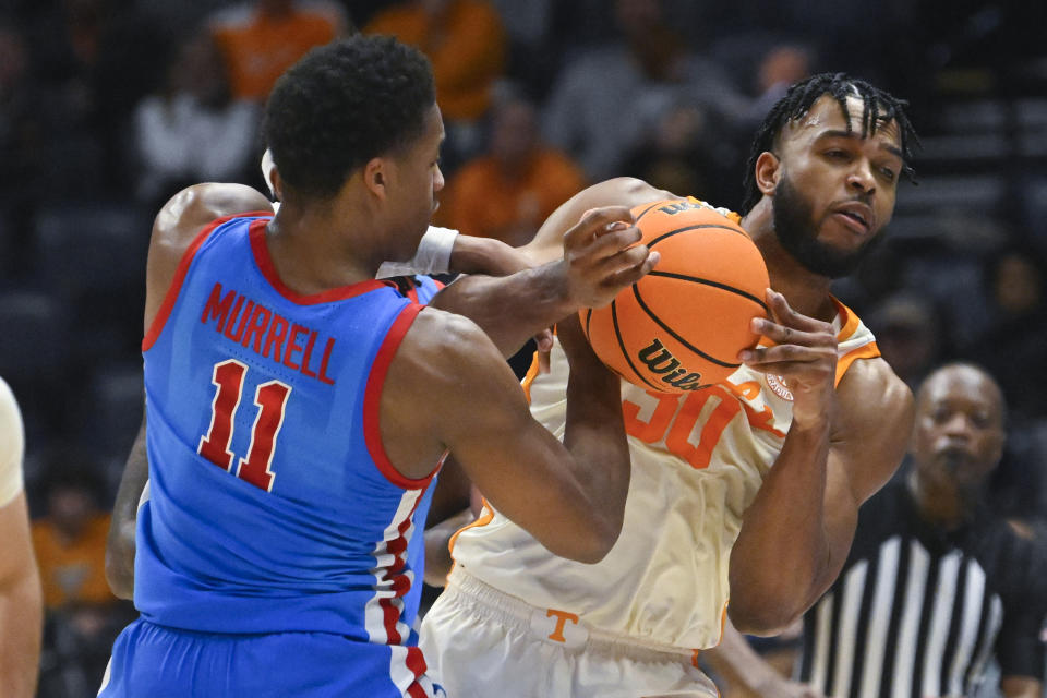 Tennessee guard Josiah-Jordan James (30) ties up the ball with Mississippi guard Matthew Murrell (11) during the second half of an NCAA college basketball game in the second round of the Southeastern Conference Tournament, Thursday, March 9, 2023, in Nashville, Tenn. Tennessee won 70-55. (AP Photo/John Amis)