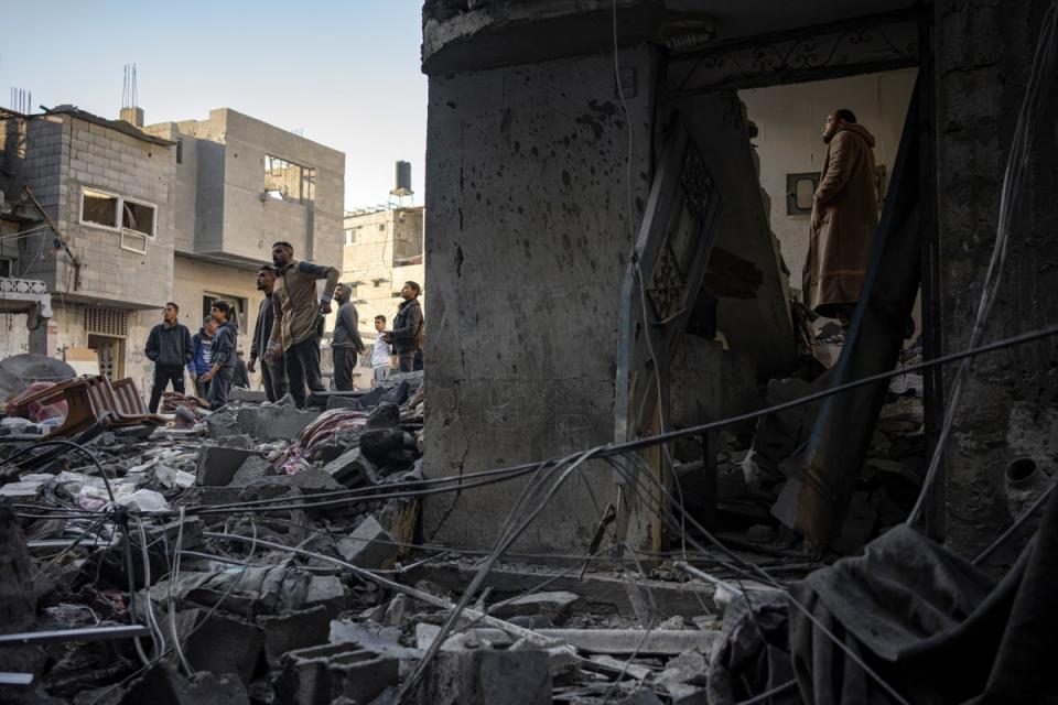 Palestinians look at houses destroyed in the Israeli bombardment of the Gaza Strip (AP)