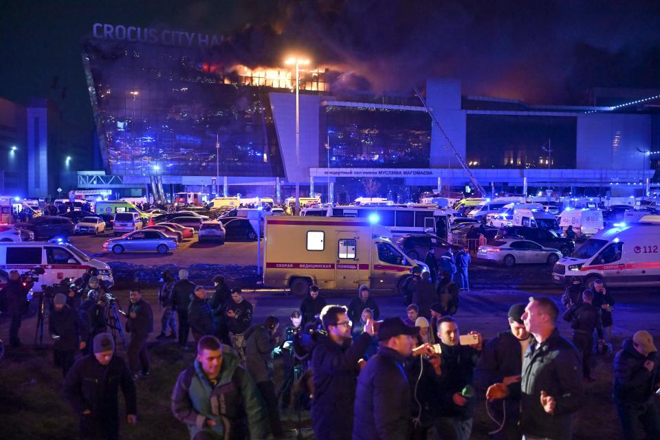 A man speaks to journalists as a massive blaze seen over the Crocus City Hall on the western edge of Moscow on March 22, 2024.