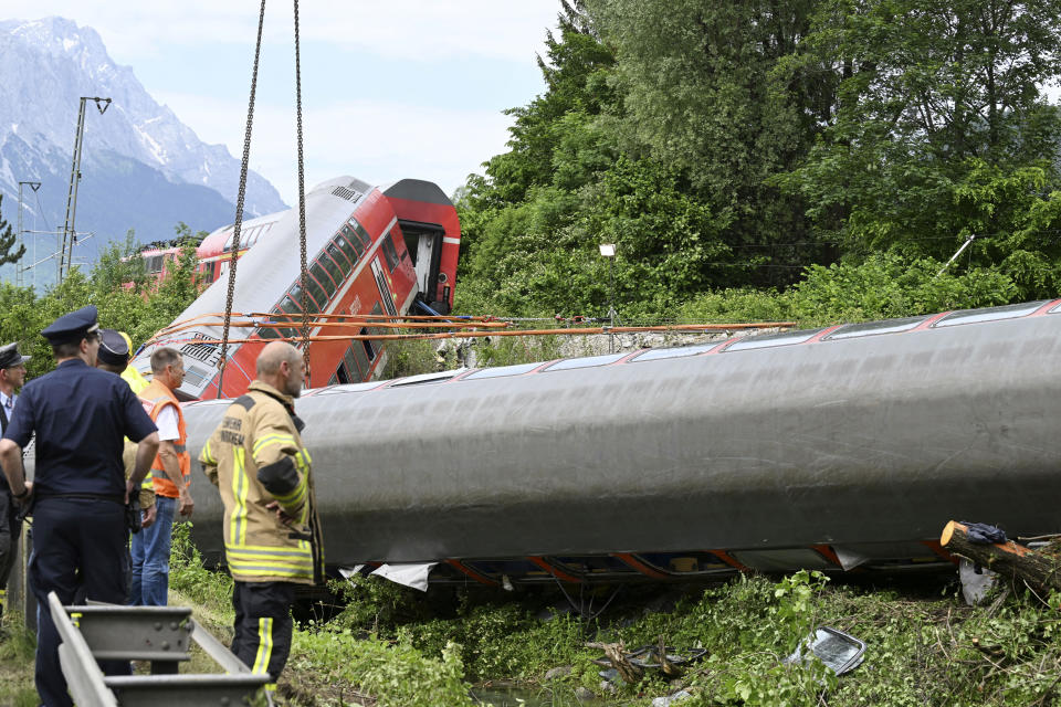 Rescue personnel work at the site of a train crash in Burgrain, near Garmisch-Partenkirchen, Germany, Saturday, June 4, 2022. Authorities say a train accident in the Alps in southern Germany on Friday left at least four people dead and many more injured. Police said the regional train headed for Munich appears to have derailed shortly after noon in Burgrain — just outside the resort town of Garmisch-Partenkirchen, from where it had set off. Three of the double-deck carriages overturned at least partly, and people were pulled out of the windows to safety. (Angelika Warmuth/dpa via AP)