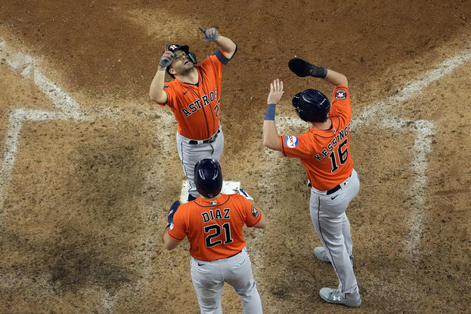 Houston Astros' Jose Altuve (27) celebrates with Yainer Diaz (21) and Grae Kessinger (16) after all three scored on Altuve's home run during the ninth inning in Game 5 of the baseball American League Championship Series against the Texas Rangers Friday, Oct. 20, 2023, in Arlington, Texas. (AP Photo/Godofredo A. Vásquez)