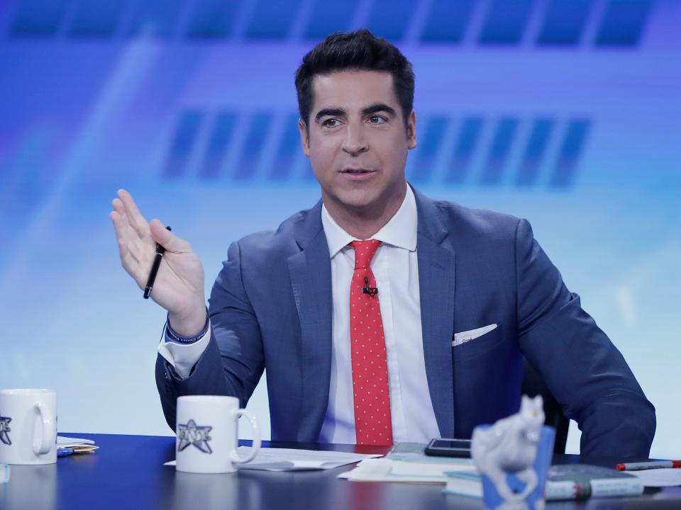 Fox News host Jesse Watters gestures with a pen in his right hand.