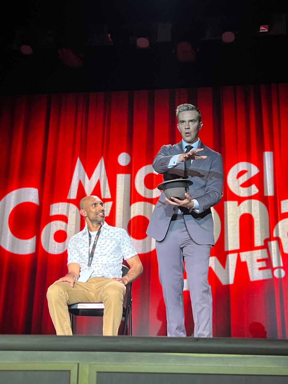 Ronak Patel on stage with magician Michael Carbonaro.