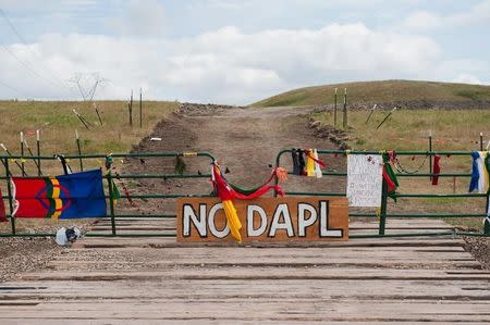 Signs left by protesters demonstrating against the Energy Transfer Partners Dakota Access oil pipeline sit at the gate of a construction access road near the Standing Rock Sioux reservation in Cannon Ball, North Dakota, September 6, 2016. REUTERS/Andrew Cullen