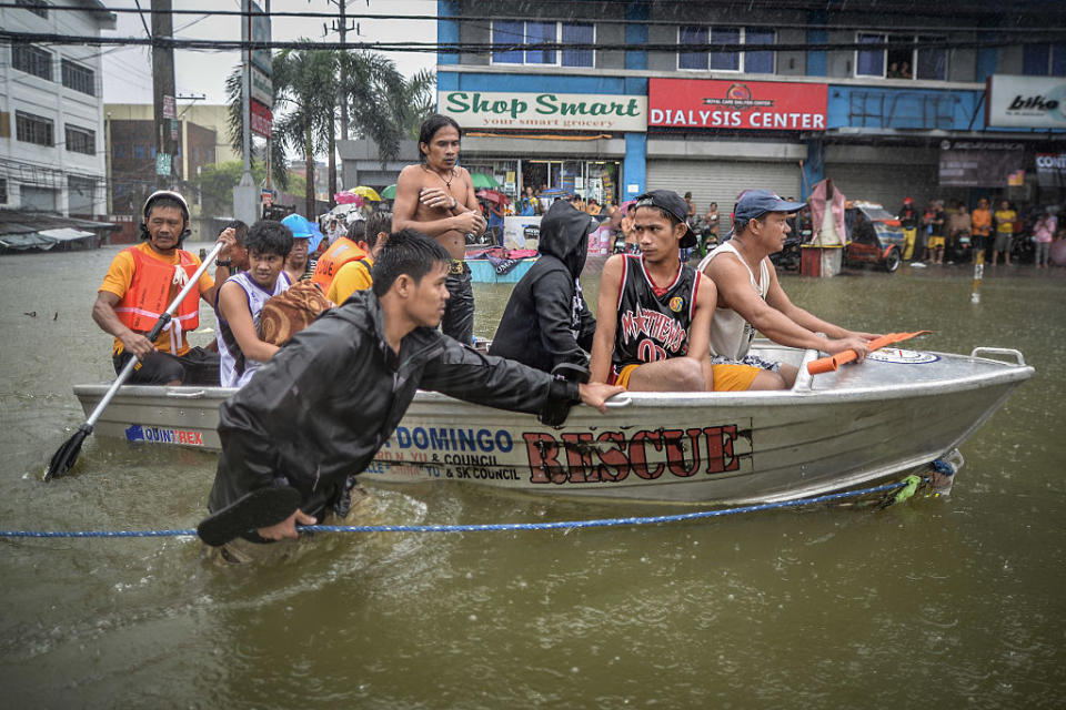 Flood victims are evacuated in a rescue boat after their homes were swamped by heavy flooding in Quezon city, suburban Manila, Philippines, Sept. 19, 2014. | NurPhoto—Corbis via Getty Images