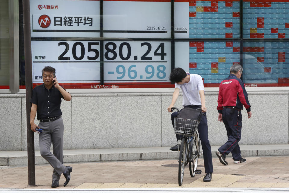 People stand by an electronic stock board of a securities firm in Tokyo, Wednesday, Aug. 21, 2019. Asia stock markets followed Wall Street lower Wednesday as investors looked ahead to a speech by the Federal Reserve chairman for signs of possible plans for more U.S. interest rate cuts. (AP Photo/Koji Sasahara)