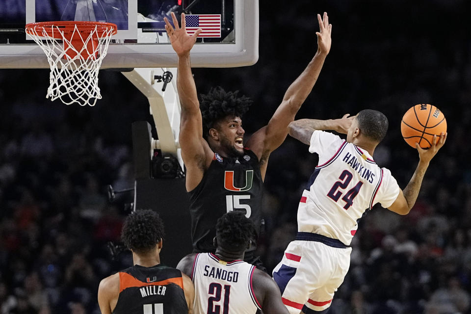 Connecticut guard Jordan Hawkins shoots around Miami forward Norchad Omier during the second half of a Final Four college basketball game in the NCAA Tournament on Saturday, April 1, 2023, in Houston. (AP Photo/David J. Phillip)