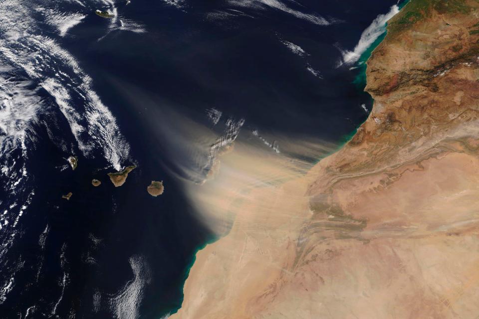 This Saturday, Feb. 22, 2020 image made available by NASA shows a dust storm approaching the Canary Islands, center, off the coast of Morocco.