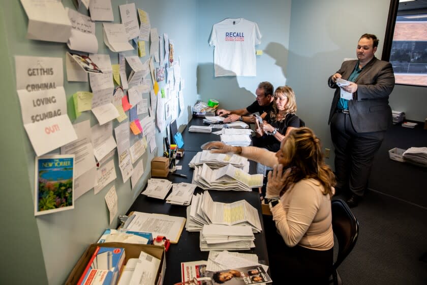 Los Angeles, CA - June 01: South Bay Field Manager Karen Shonka, bottom, volunteers Ana and Mark Brown (black shirts), from Downey, and Gerald Sirotnak, Gateway Cities Field Manager, right, open envelopes and separate mailed-in items at a field office for the "Recall D.A. George Gascon," campaign, in Los Angeles, CA, Wednesday, June 1, 2022. (Jay L. Clendenin / Los Angeles Times)