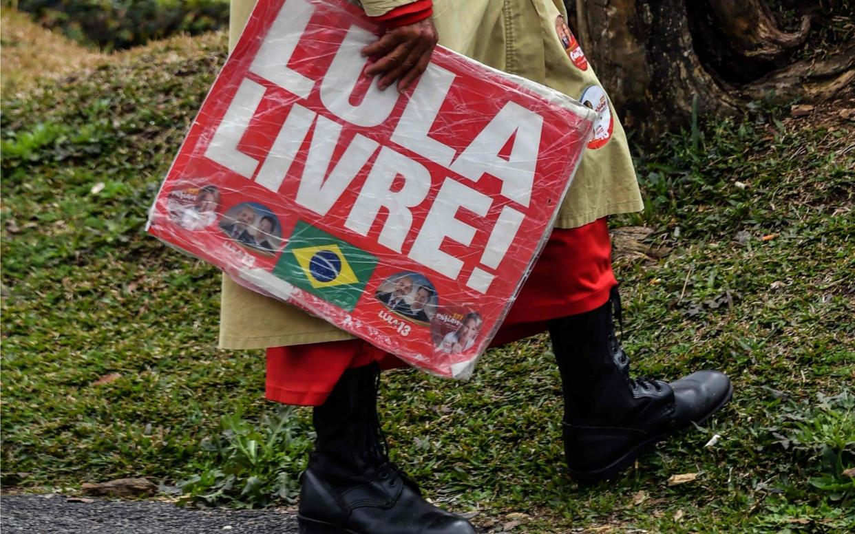 A supporter of Brazilian former president Luiz Inacio Lula Da Silva holds a sign reading
