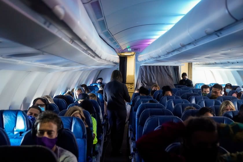 HONOLULU, HI - OCTOBER 15: Masked passengers, aboard a Hawaiian Airlines flight from Los Angeles International Airport to Honolulu International Airport on Thursday, Oct. 15, 2020 above the Pacific Ocean. Amid the ongoing Coronavirus pandemic, the State of Hawaii is trying to restart its tourism economy; October 15 was the start of a new traveler testing program, with thousands of people expected to arrive to the state. (Kent Nishimura / Los Angeles Times)