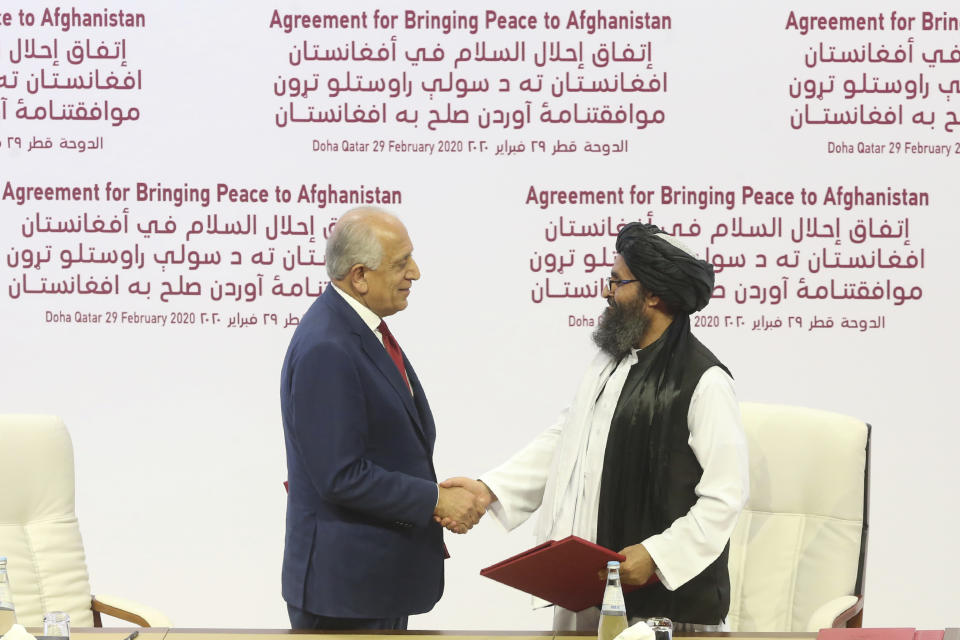 FILE - In this Feb. 29, 2020, file photo, U.S. peace envoy Zalmay Khalilzad, left, and Mullah Abdul Ghani Baradar, the Taliban group's top political leader shake hands after signing a peace agreement between Taliban and U.S. officials in Doha, Qatar. The Taliban on Tuesday, Sept. 7, 2021, announced a caretaker Cabinet that paid homage to the old guard of the group, giving top posts to Taliban personalities who dominated the 20-year battle against the U.S.-led coalition and its Afghan government allies. Baradar, who had led talks with the U.S. and signed the deal that led to America’s final withdrawal from Afghanistan, will be one of two deputies to the new Interim Prime Minister Mullah Hasan Akhund. (AP Photo/Hussein Sayed, File)
