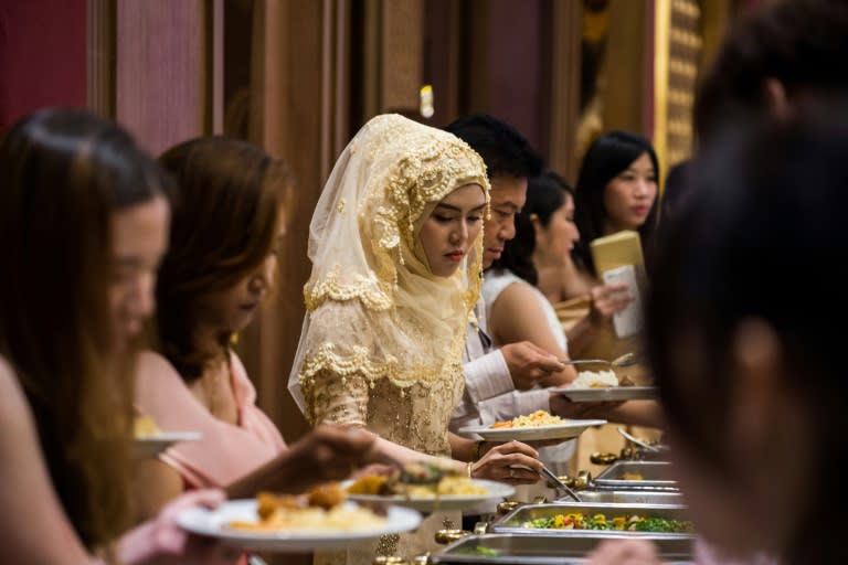 Guests choose halal food items during a wedding reception at the Al Meroz hotel in Bangkok
