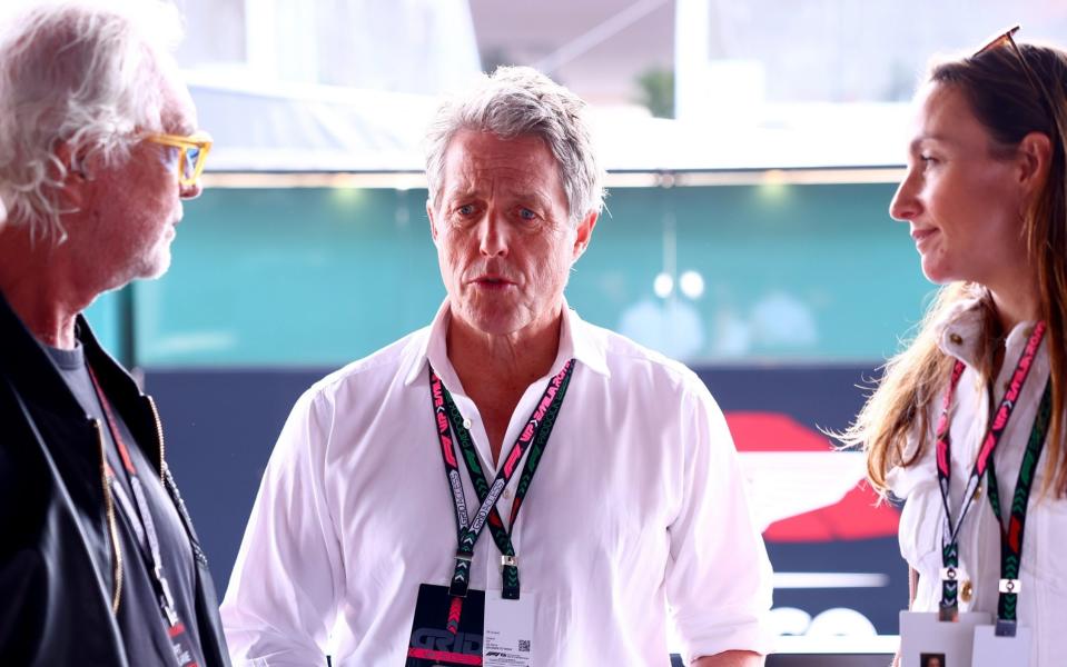 Hugh Grant speaks to Flavio Briatore