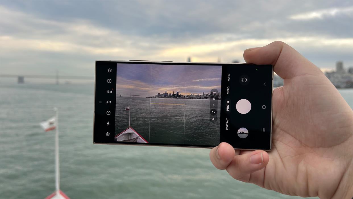  Samsung Galaxy S24 Ultra held horizontally filming a cityscape from across a river water. 