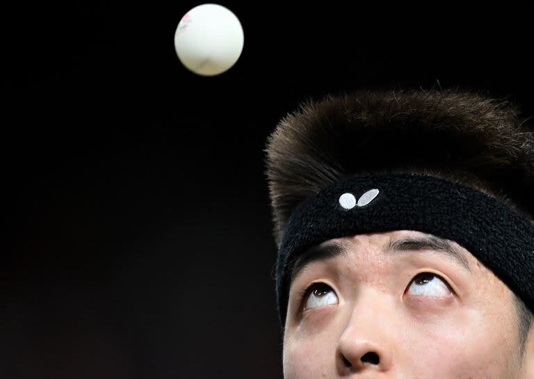 El alemán Dang Qiu mira la pelota mientras se prepara para servirla al portugués Tiago Apolonia durante su ronda de 64 individuales de tenis de mesa masculino en los Juegos Olímpicos de París 2024