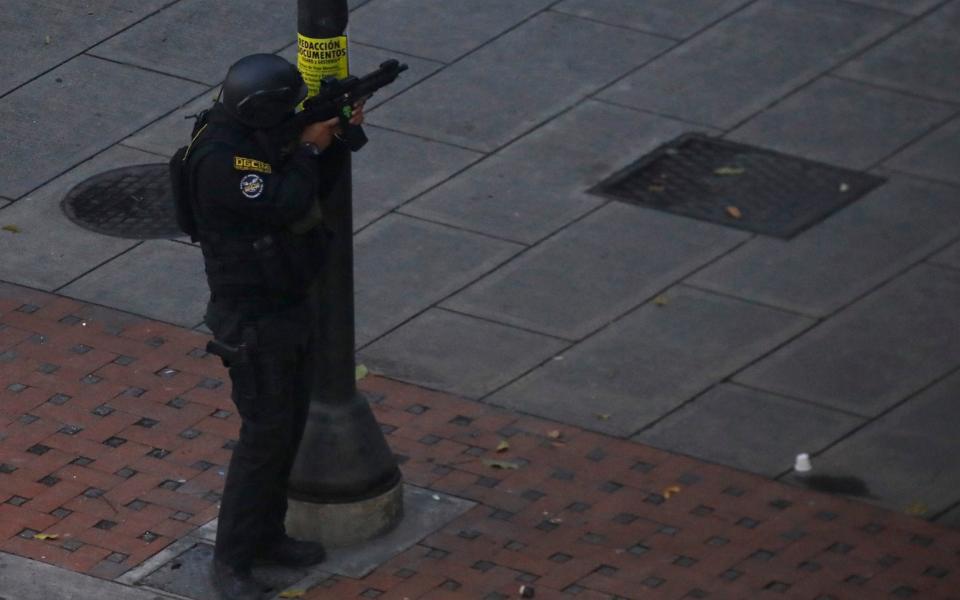 A security forces member aims his weapon after clashes broke out with opposition supporters  - Credit: Reuters