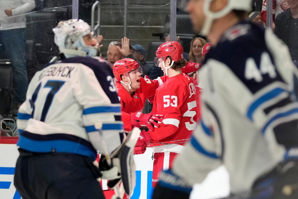 Detroit Red Wings left wing Lucas Raymond, left, celebrates his goal on Winnipeg Jets goaltender Connor Hellebuyck (37) with teammate defenseman Moritz Seider (53) during the second at Little Caesars Arena in Detroit on Thursday, Oct. 26, 2023.