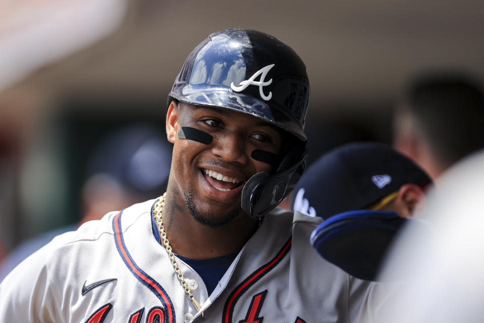 Atlanta Braves' Ronald Acuna Jr. celebrates with teammates in the dugout after scoring a run during the third inning of a baseball game against the Cincinnati Reds in Cincinnati, Sunday, June 27, 2021. (AP Photo/Aaron Doster)