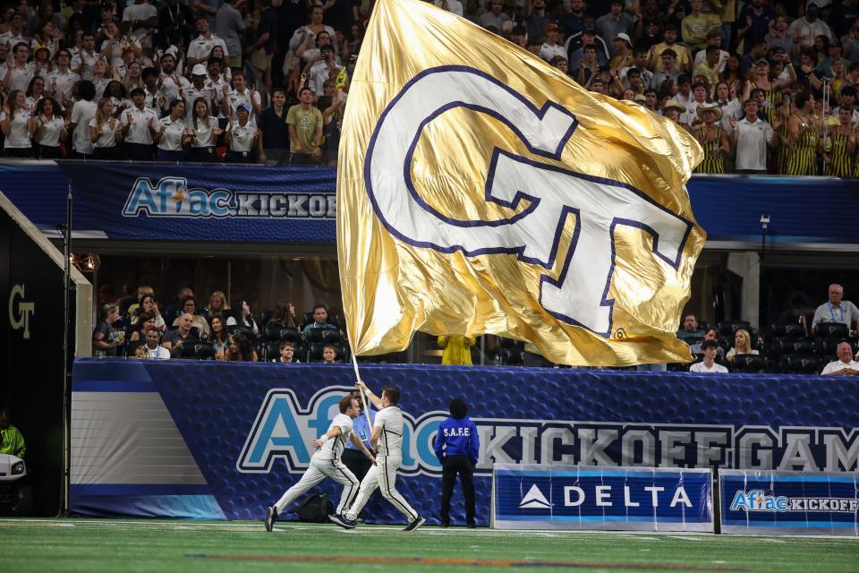 Sep 1, 2023; Atlanta, Georgia, USA; Georgia Tech Yellow Jackets cheerleaders run a flag after a touchdown against the Louisville Cardinals in the second quarter at Mercedes-Benz Stadium. Mandatory Credit: Brett Davis-USA TODAY Sports