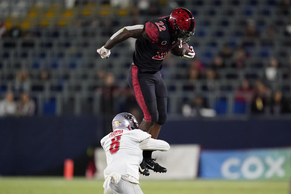 San Diego State running back Greg Bell (22) is tackled by New Mexico cornerback Donte Martin (8) during the first half of an NCAA football game Saturday, Oct. 9, 2021, in Carson, Calif. (AP Photo/Ashley Landis)