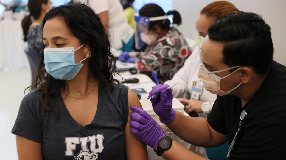 Camila Gutierrez, a junior at Florida International University, receives a Pfizer-BioNtech COVID-19 vaccine in Miami in April from Jason Rodriguez, a pharmacy student, at the Jackson Memorial Hospital. 