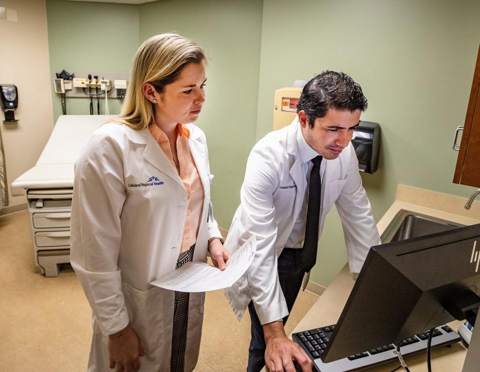 First-year resident Dr. Emma Weiland, left, works with Dr. Daniel Lugo, program director for internal medicine at Lakeland Regional Health in Lakeland last week. Weiland, who graduated medical school from the University of South Florida, is among 70 residents starting at Lakeland Regional Health.