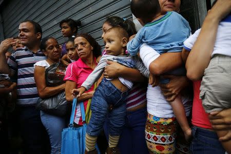 People line up to buy toilet paper and baby diapers at a supermarket in downtown Caracas January 19, 2015. REUTERS/Jorge Silva