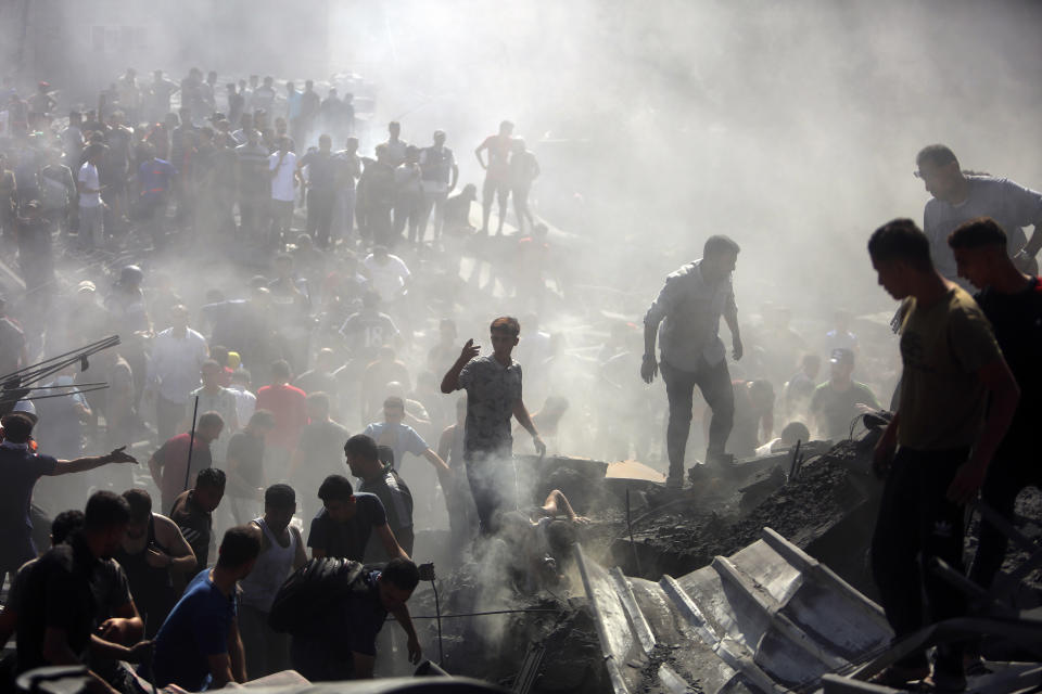 Palestinians inspect the rubble of destroyed buildings following Israeli airstrikes on the town of Khan Younis, southern Gaza Strip, Thursday, Oct. 26, 2023. (AP Photo/Mohammed Dahman)