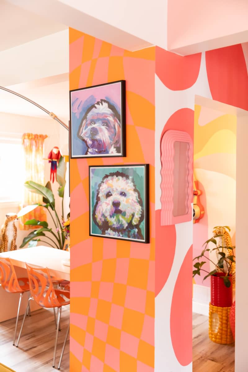 Colorful dog portraits on pink and orange walls.