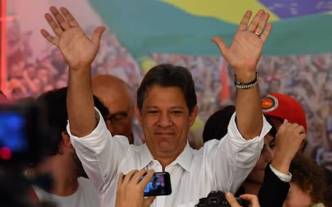 Brazilian presidential candidate for the Workers' Party, Fernando Haddad, waves at supporters in Sao Paulo, Brazil after his defeat - Credit: AFP