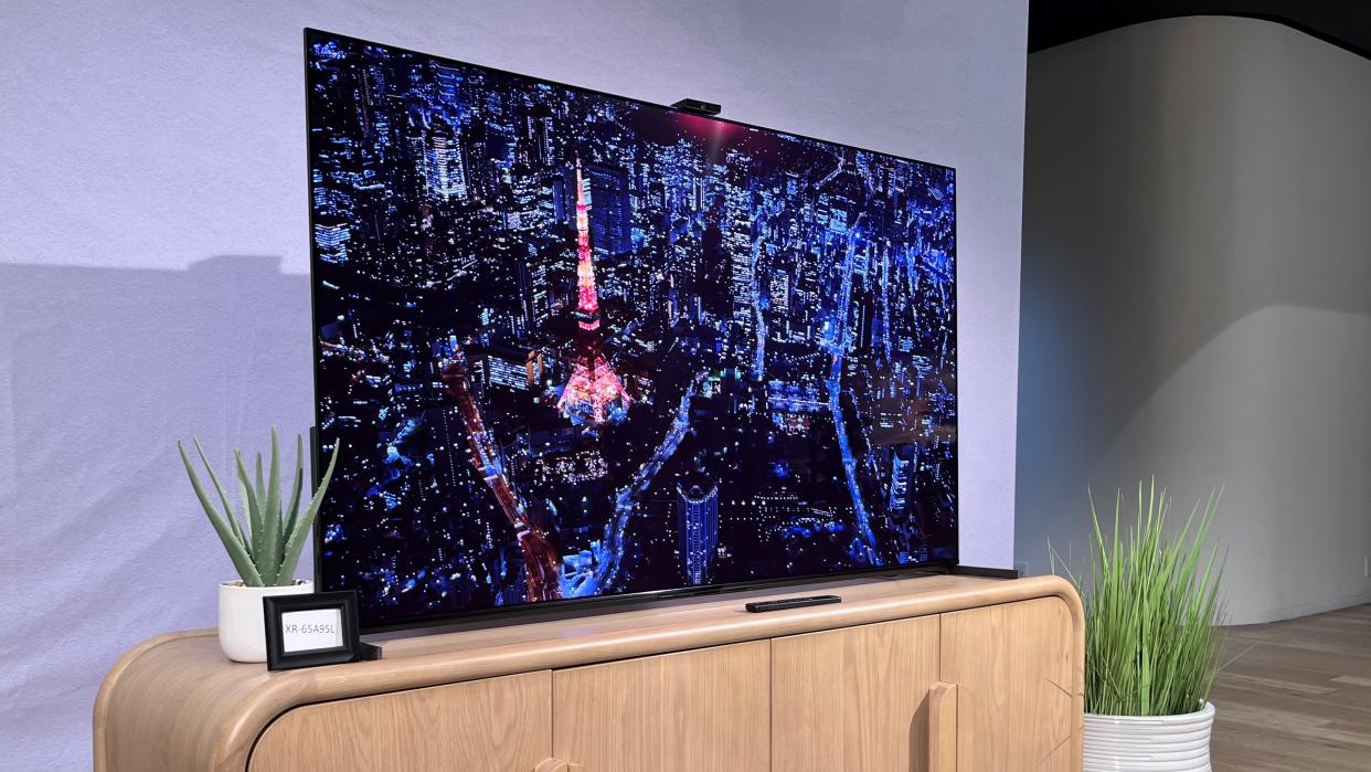  Sony-A95L QD-OLED TV on TV stand shown from side angle with city image onscreen 