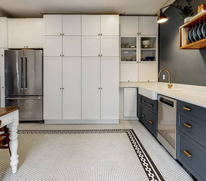 Kitchen with tall white cabinets, blue drawers and black and white floors