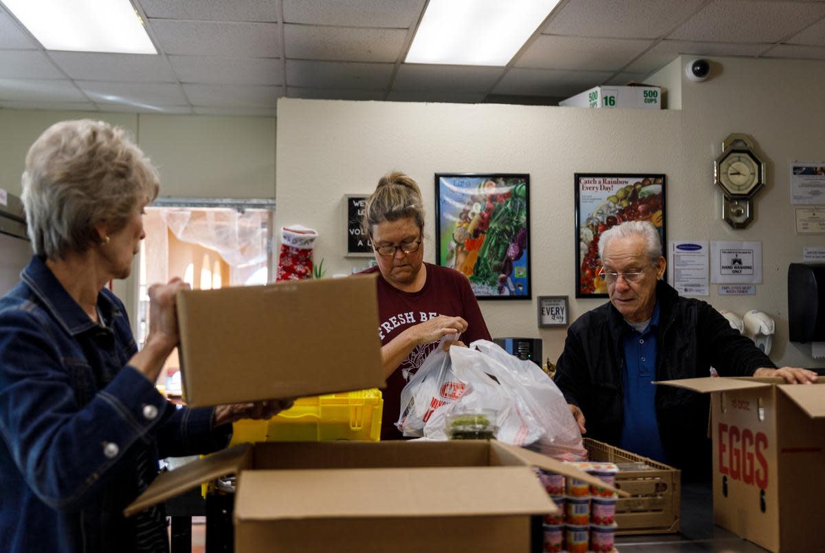 Volunteers from left to right, Evelyn McMillen, Leigh Cox and Victor Surita help to package orders of groceries at El Buen Samaritano food pantry in Austin, Texas on Nov. 14, 2023.