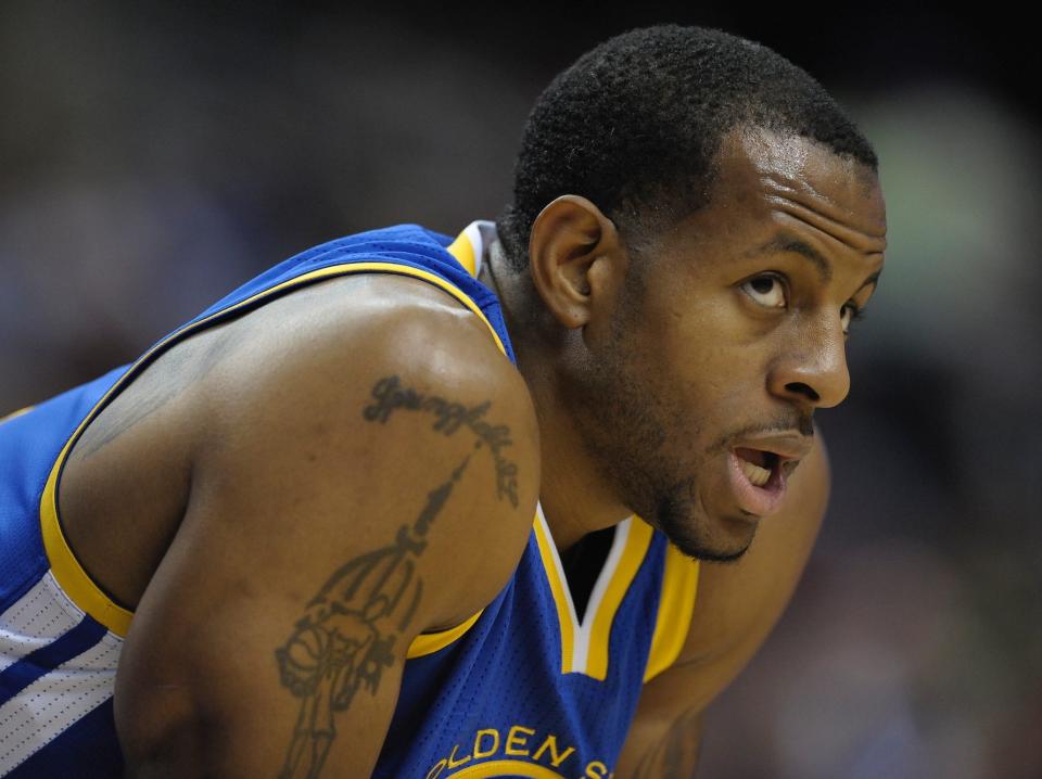 Andre Iguodala leans over and looks on during a game in 2013.