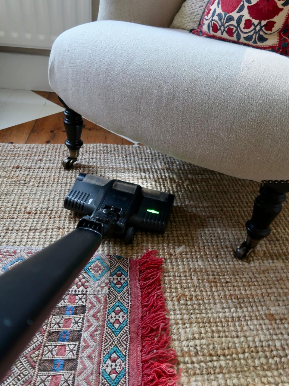 Shark cordless vacuum cleaning under a chair. (Supplied)