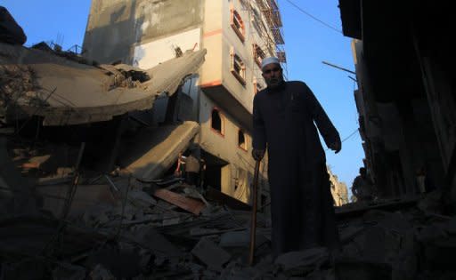 A Palestinian walks amongst the debris of destroyed homes following an Israeli air strike in Gaza City. Israeli strikes killed 32 Palestinians on Monday, taking the Gaza death toll to 109 as UN chief Ban Ki-moon joined efforts to end the worst violence in four years and Israel's inner circle of ministers mulled their next move