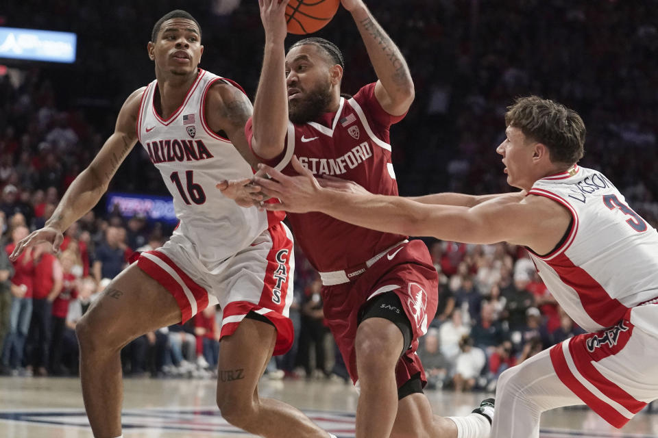 Stanford's Jared Bynum, center, drives to the basket between Arizona's Keshad Johnson (16) and Pelle Larsson (3) during the first half of an NCAA college basketball game Sunday, Feb. 4, 2024, in Tucson, Ariz. (AP Photo/Darryl Webb)