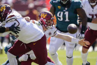 Washington Commanders quarterback Carson Wentz (11) looses the ball as he gets hit by Philadelphia Eagles defensive end Brandon Graham (55) during the first half of an NFL football game, Sunday, Sept. 25, 2022, in Landover, Md. (AP Photo/Alex Brandon)