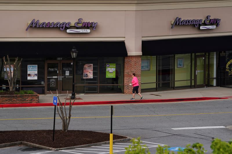 A woman walks past a closed massage parlor days before the phased reopening of businesses from coronavirus disease rules in Atlanta