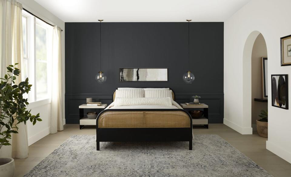 a bedroom with a large bed and soft black walls