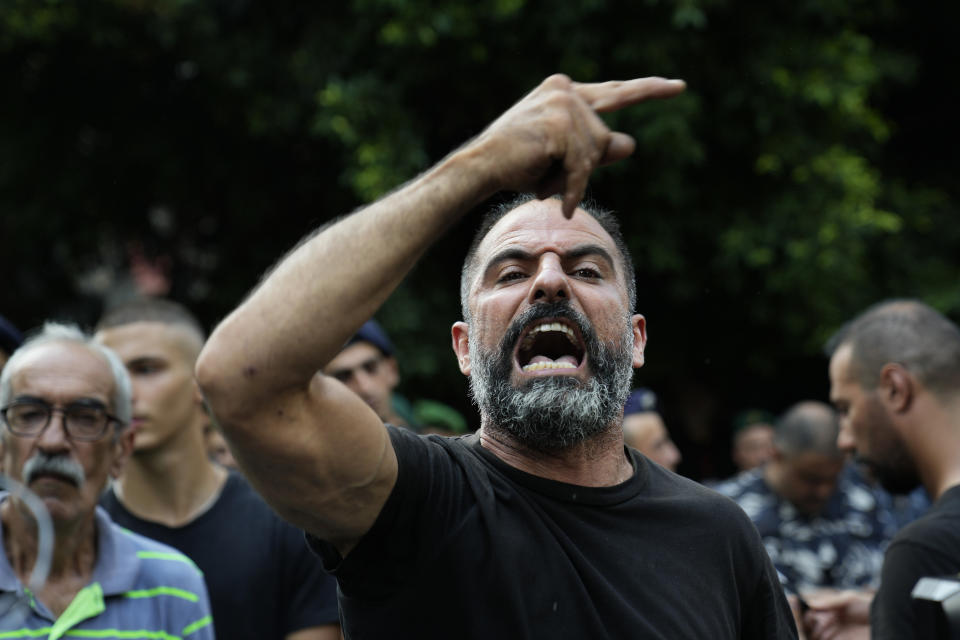 A protester who arrived to support an armed man who takes hostages inside a bank, shouts slogans against the Lebanese banks, in Beirut, Lebanon, Thursday, Aug. 11, 2022. A hostage standoff in which a gunman demanded a Beirut bank let him withdraw his trapped savings so that he could pay his father's medical bills ended seven hours later with the man's surrender Thursday. (AP Photo/Hussein Malla)