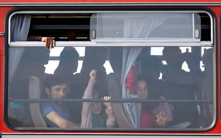 Syrian migrants sit in a bus to register in a camp after they crossed the Hungarian-Serbian border near Roszke, Hungary August 25, 2015. REUTERS/Laszlo Balogh