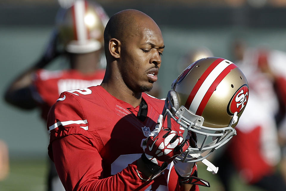 FILE - In this Jan. 15, 2014 file photo, San Francisco 49ers cornerback Carlos Rogers adjusts his helmet during practice at an NFL football training facility in Santa Clara, Calif. Ten former NFL players have been charged with defrauding the league’s healthcare benefit program. They include five who played on the Washington Redskins, including Clinton Portis and Carlos Rogers. (AP Photo/Jeff Chiu)