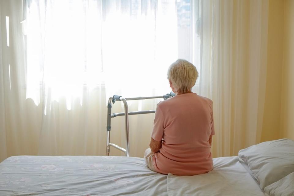 Elderly woman in nursing home room holding walking frame with wrinkled hand. Senior lady grabbing metal walker's handles. Interior background, copy space, close up. Asset ID: 2071674866